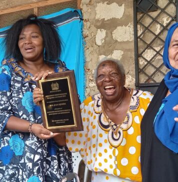 (From Left to Right: CAS Racheal Shebesh (L) handing Ms Joan Mjomba (C) the Kenya Eminent Women Trailblazers Recognition Award flagged by unidentified woman (R).