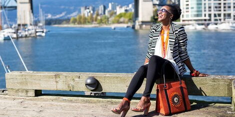Entrepreneur Jackee Kasandy, with a sample of her bag collection posing for a photo. |Photo| Courtesy|