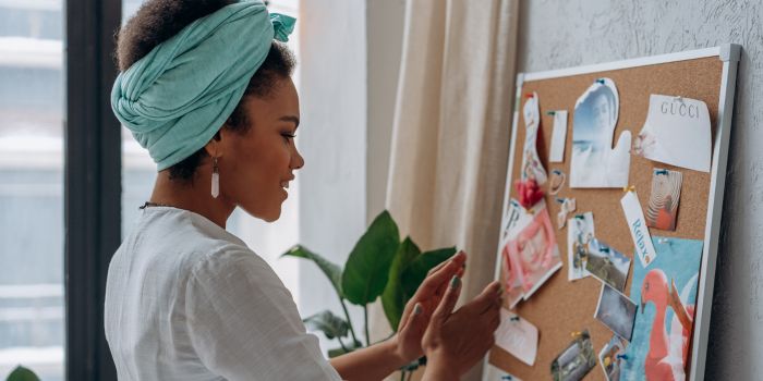 A woman sets her goals on a vision board