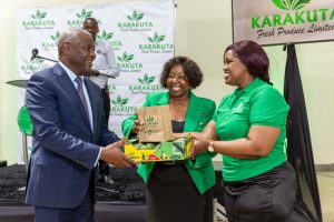 Equity Group Managing Director and CEO Dr James Mwangi (left) receives first-off the packing line box of avocados from Karakuta Fresh Produce CEO Grace Ngungi (centre) and Karakuta Administrator Virginiah Njogu (right).