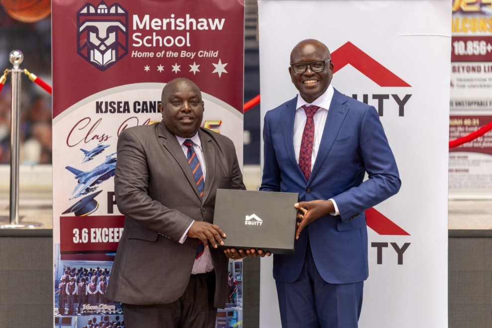 Equity Bank Managing Director Moses Nyabanda gifts Merishaw School Chief Principal David Kariuki an Equity laptop.